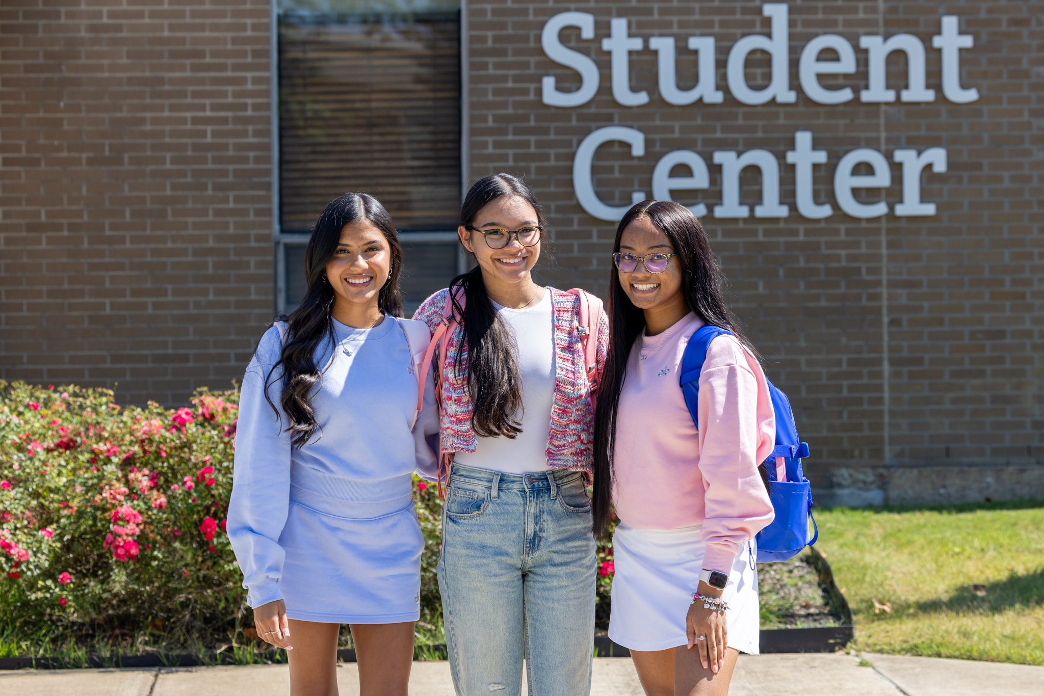 Three students pose in front of the JSCC Student Center building during the first week of Fall 2026 classes.