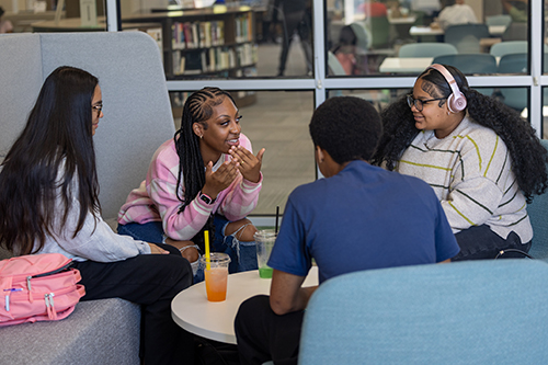 Students gather around a table in the Decompression Room in the newly renovated JSCC Learning Commons.