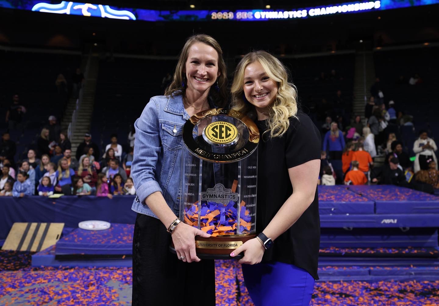 Photo of Aubrey Wright holding the SEC Gymnastics trophy after the Florida Gators won.