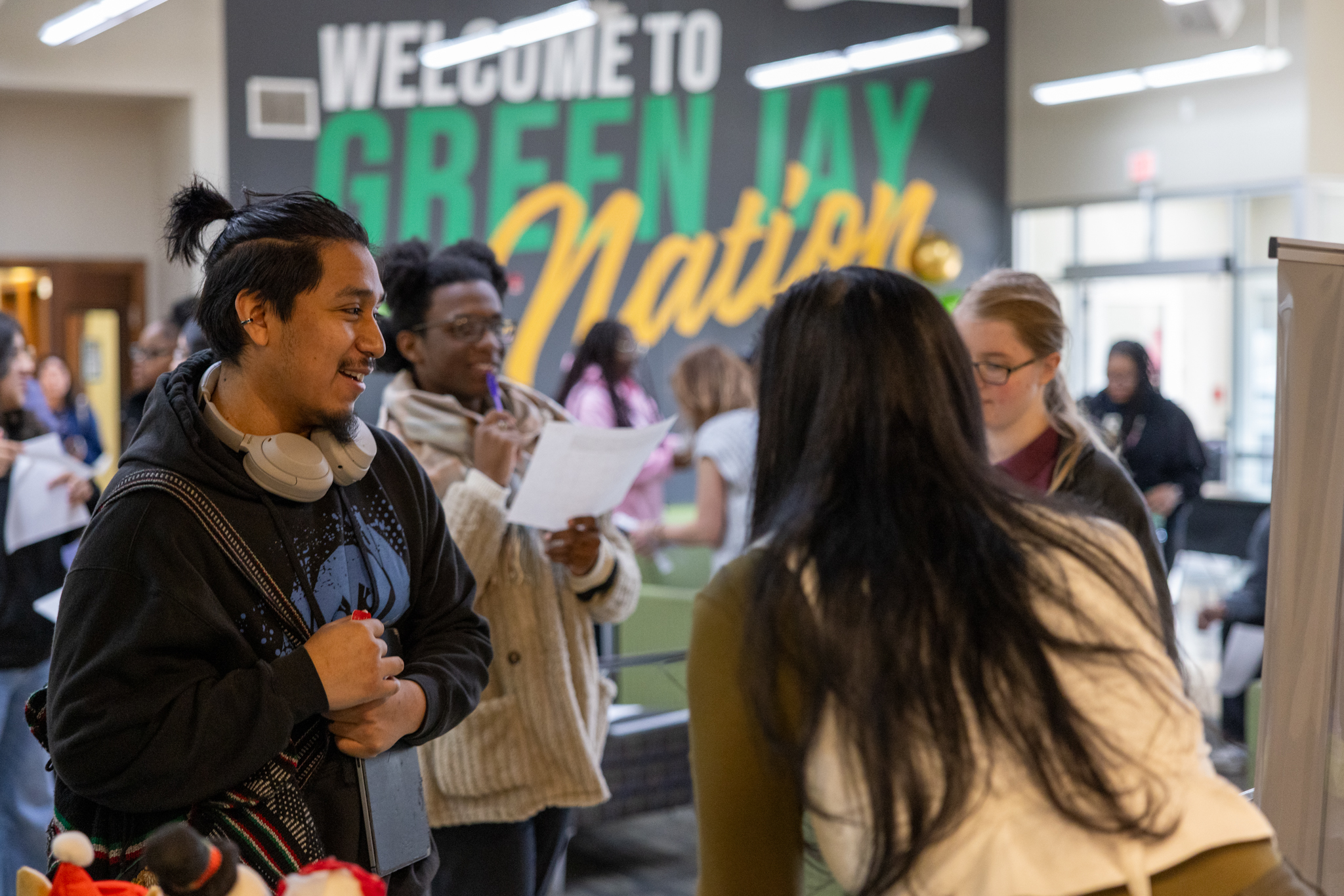 Photo of a student interacting with other students and an involvement fair in the student center. 
