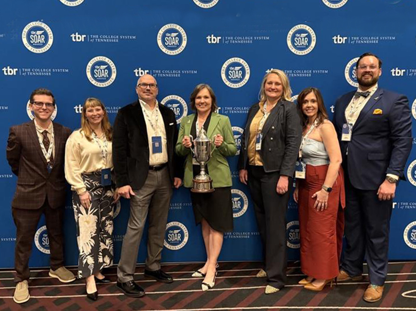 Members of the TBR leadership team pose in front of the SOAR Awards backdrop with President Rothstein holding the trophy for College of the Year.